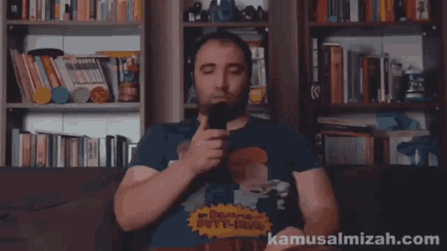 a man wearing a beavis and butthead shirt holds a remote