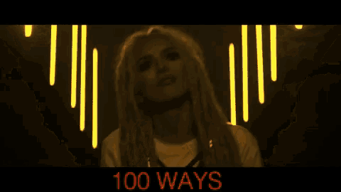 a woman with dreadlocks is standing in front of a glowing heart with the words 100 ways below her