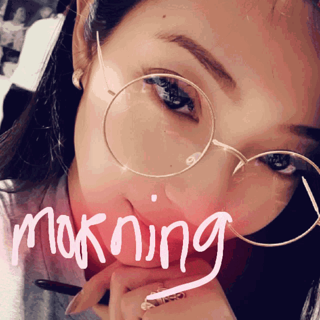 a close up of a woman wearing glasses with the word morning written on her face