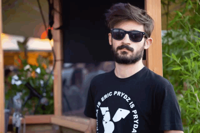 a man wearing sunglasses and a black shirt that says eric prydz is fryda