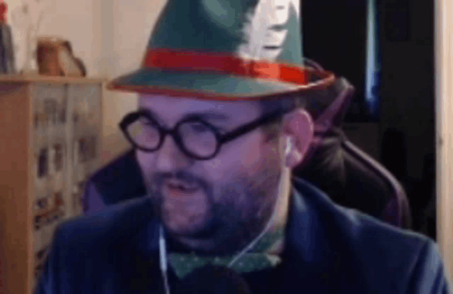 a man wearing a hat , glasses and a bow tie .