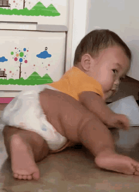 a baby wearing a diaper is crawling on the floor .
