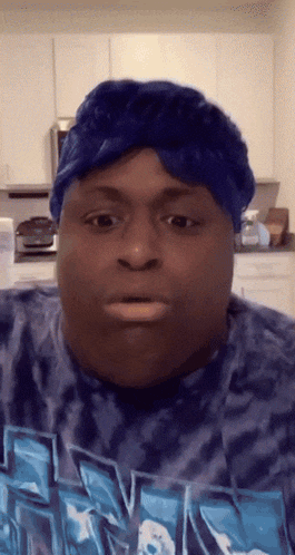 a man wearing a blue headband and a tie dye shirt