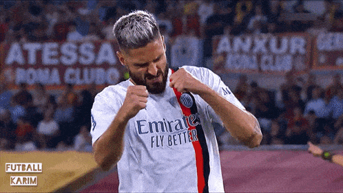 a man in an emirates fly better jersey celebrates