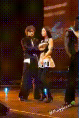 a man and a woman are dancing on a stage with the number 21 visible