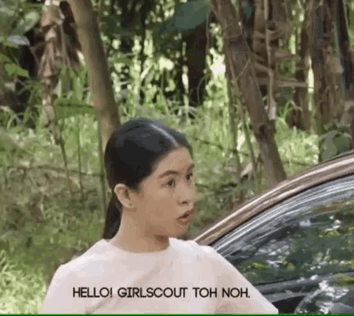a girl is standing next to a car and says hello girlscout toh non