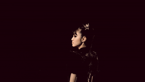 a girl with a ponytail is standing in front of a fire explosion