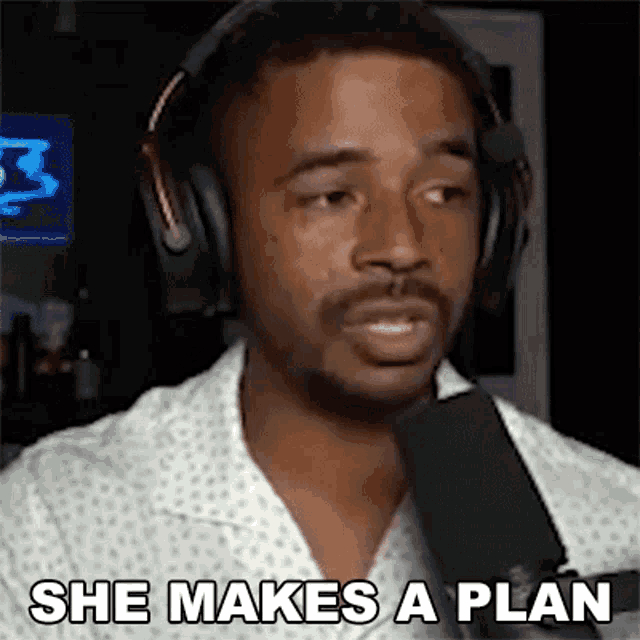 a man is wearing headphones and talking into a microphone .