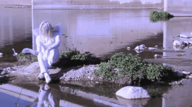 a woman is sitting on a small island in the water
