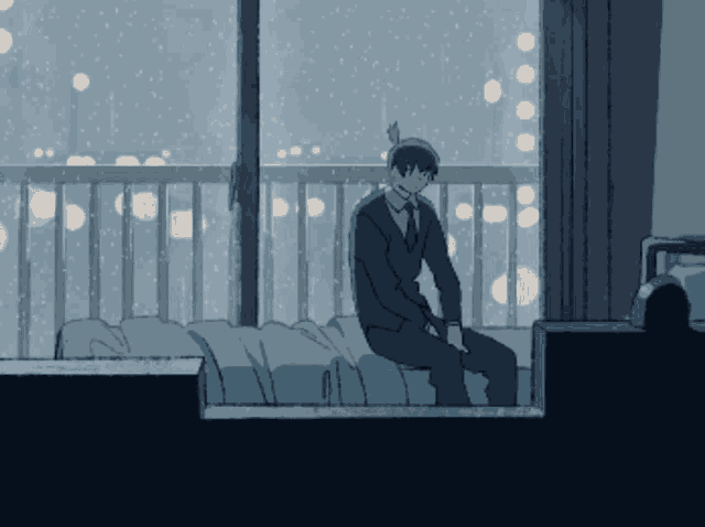 a man in a suit and tie sits on a bed in front of a window