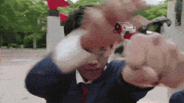 a man in a suit and tie is holding a toy gun in his hand