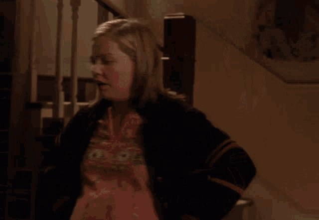 a woman says " and i 'm mad about that " in front of a staircase