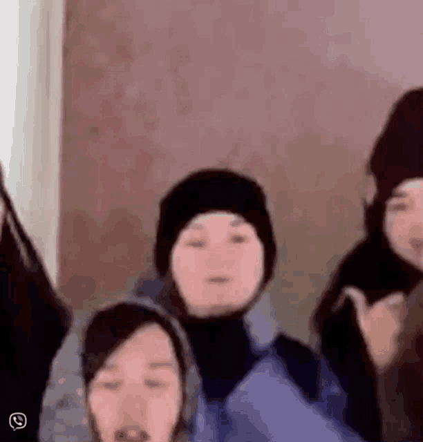 a group of people are standing next to each other and one of them is wearing a hat .