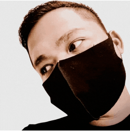 a man wearing a black face mask looks to his left