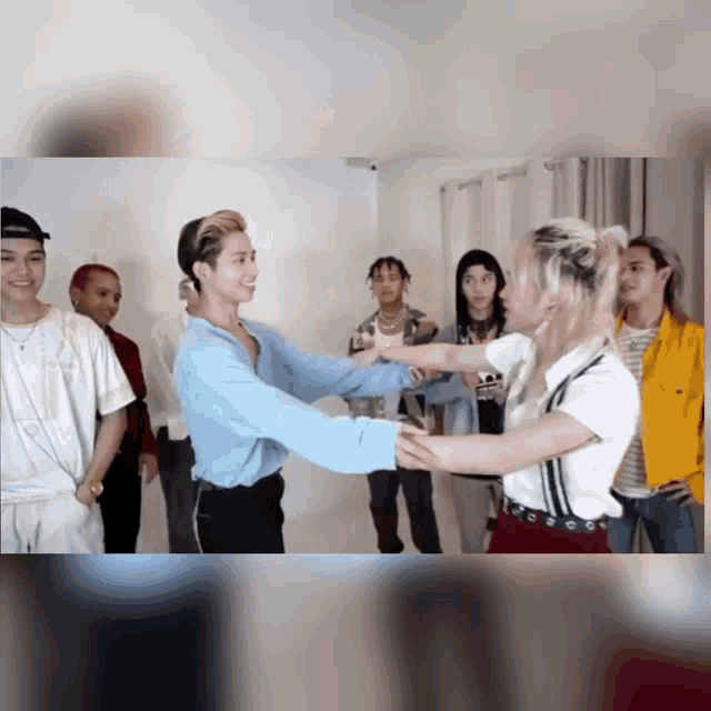 a group of young people are standing in a room and dancing