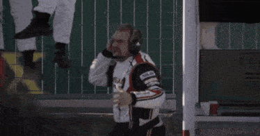 a man wearing a nissan nismo jacket looks at something