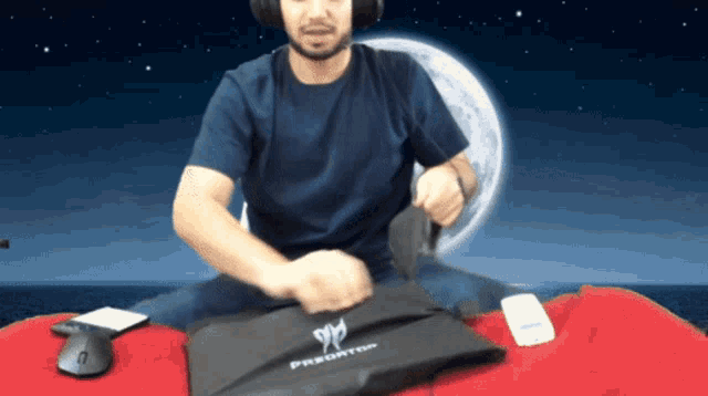 a man wearing headphones holds a bag that says predator