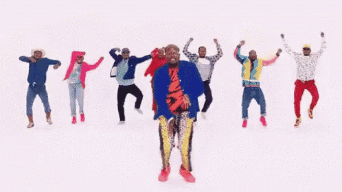 a group of men in colorful clothes are dancing together .