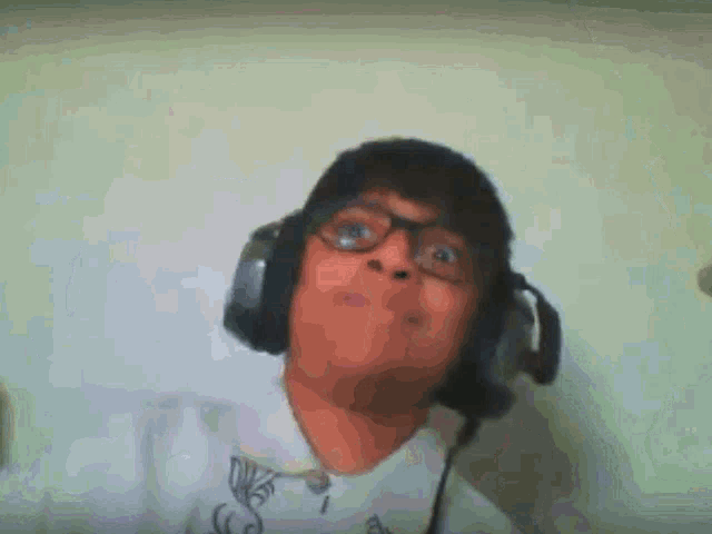 a man wearing glasses and headphones looks at the camera