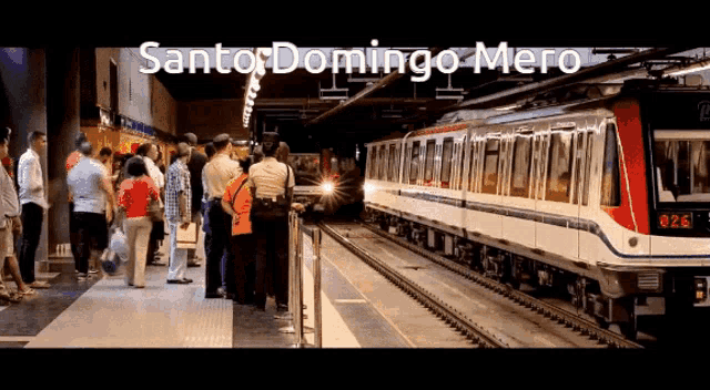 a group of people are waiting for a train at a station that says " santor domingo mero "