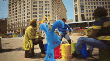 a group of people playing with buckets and a stuffed animal
