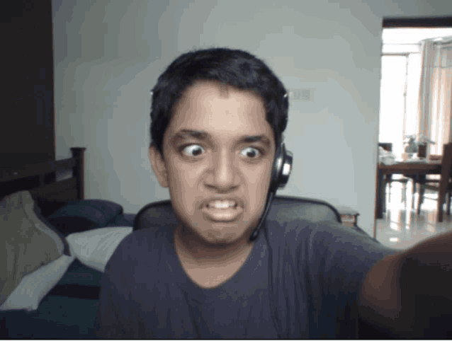 a young boy wearing headphones is making a face