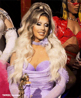 a woman in a purple dress is holding a doll in her hand .