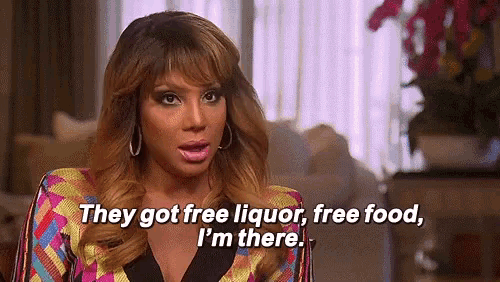 a woman is sitting in a living room talking about free liquor , free food , and i 'm there .