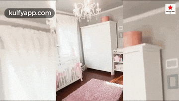 a baby girl 's nursery with a pink rug and a white crib .