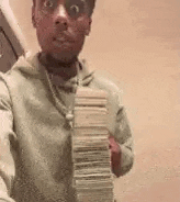 a man is holding a stack of money in his hand and taking a selfie .