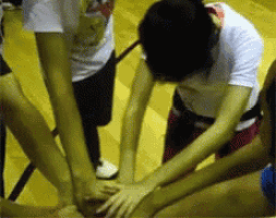 a group of people putting their hands together on a wooden floor