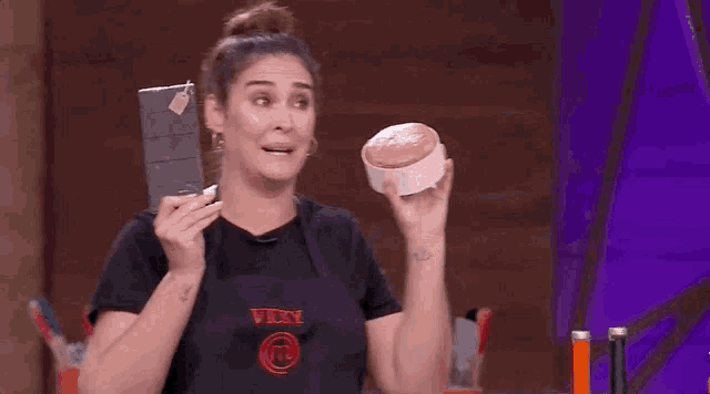 a woman in a black shirt is holding a knife and a bowl .