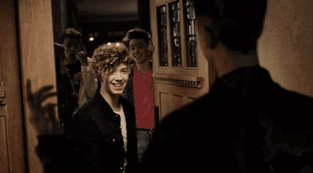 a group of young men standing in front of a door