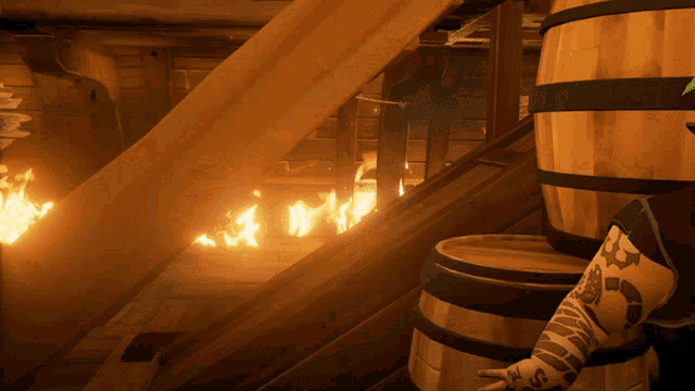 a man with a tattoo on his arm is standing next to a wooden barrel with a fire in the background
