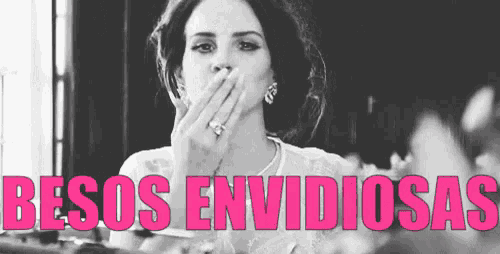 a woman is blowing a kiss in a black and white photo with the words besos envidiosas written in pink