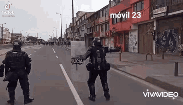 two police officers are standing on a street with a sign that says policia on it