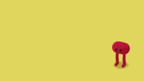 a red cartoon character is standing on a yellow background .