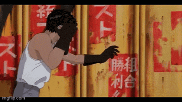 a man in boxing gloves stands in front of a wall with chinese writing on it