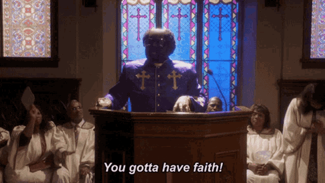 a man in a purple suit stands at a podium with the words you gotta have faith