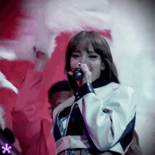a woman singing into a microphone with a purple star in the background