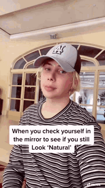 a man wearing a hat and a striped shirt says " when you check yourself in the mirror to see if you still look " natural "