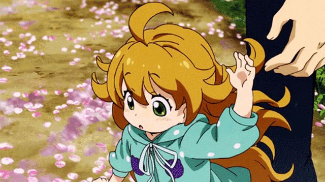 a little girl in a blue shirt is waving her hand in the air