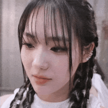 a close up of a girl 's face with braids