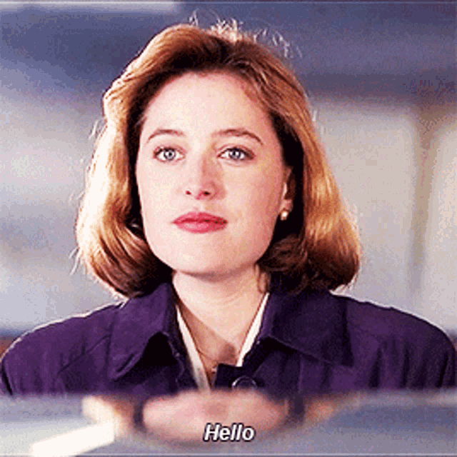 a woman in a purple coat says hello