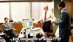 a group of men are sitting around a table and one of them says " $ 26, 000 worth of sides "