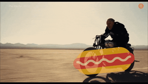 a man is riding a motorcycle with a hot dog on the front