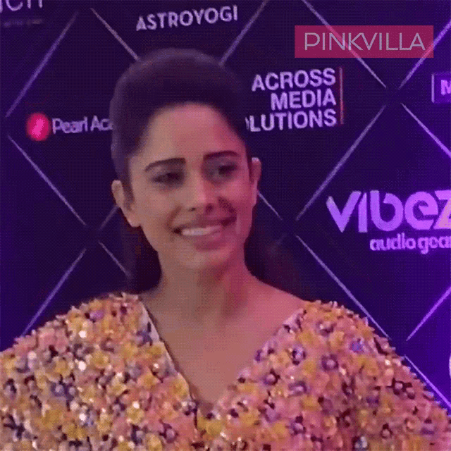 a woman is smiling in front of a vibe ad