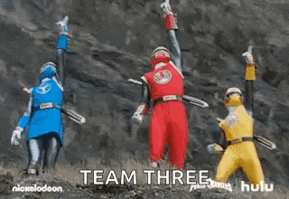 a group of power rangers are standing next to each other holding swords in front of a mountain .