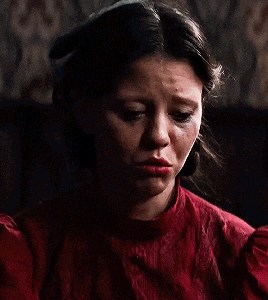 a woman in a red shirt is looking down at something