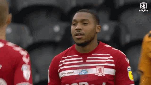 a soccer player wearing a red and white jersey with the word hummel on the front